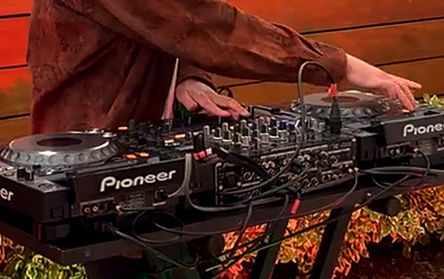 Pioneer CDJs and mixer set up for a private event in Los Angeles, lit by warm colour uplighting.